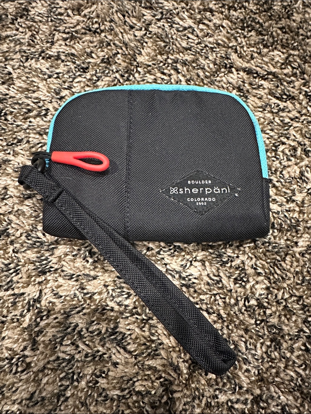 Sherpani Black Wristlet with Teal Trim and Red Pull